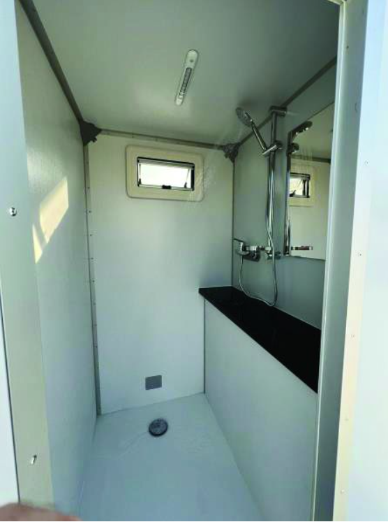 Interior of the ECOLOO unit with a shower, mirror and counter