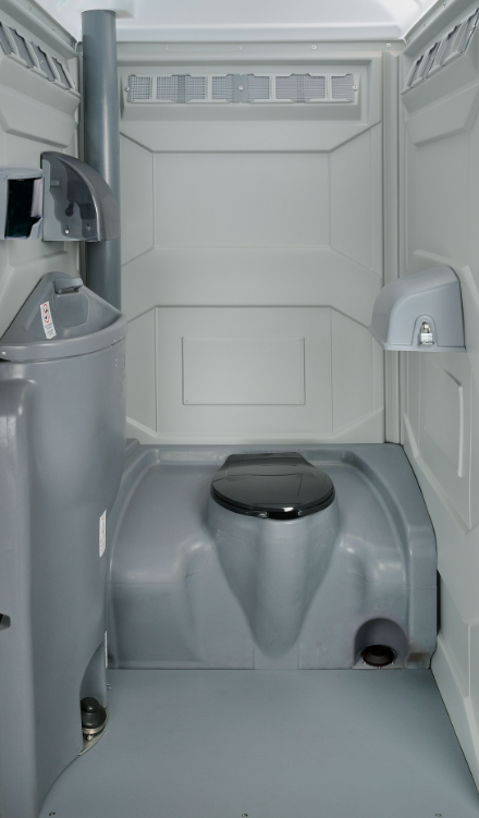 Interior of a BioClean portable toilet unit with toilet, urinal and ventilation